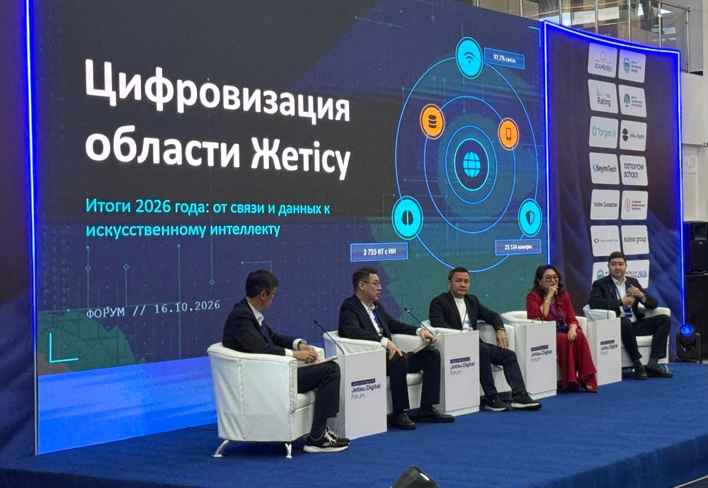 Пятеро спикеров на форуме «Цифровизация области Жетісу» на фоне большого экрана с презентацией.
