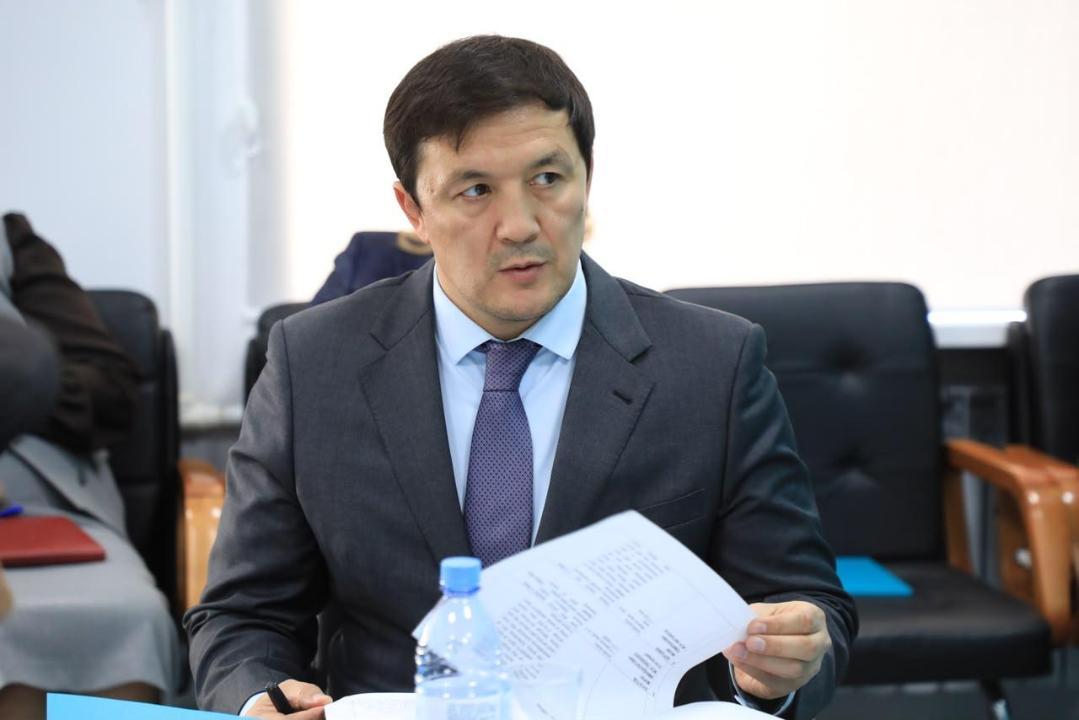 Костюм киген, қолында құжат ұстаған ер адамның суреті.