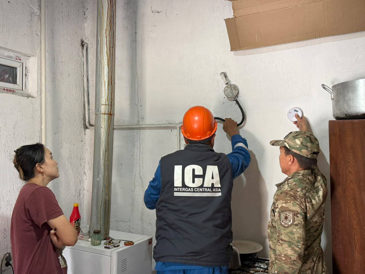 Intergas Central Asia маманы мен әскери қызметшінің үй ішіндегі газ жабдығын тексеруі.