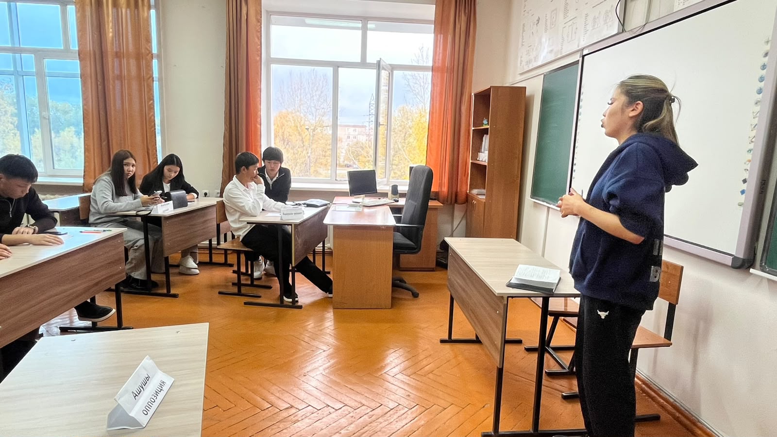 Сыныпта мұғалімнің оқушыларға сабақ түсіндіріп жатқан сәті.