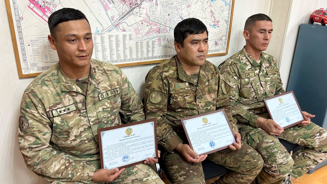 Қамирли форма киген үш әскери қолда алғыс хаттарын ұстап отыр.