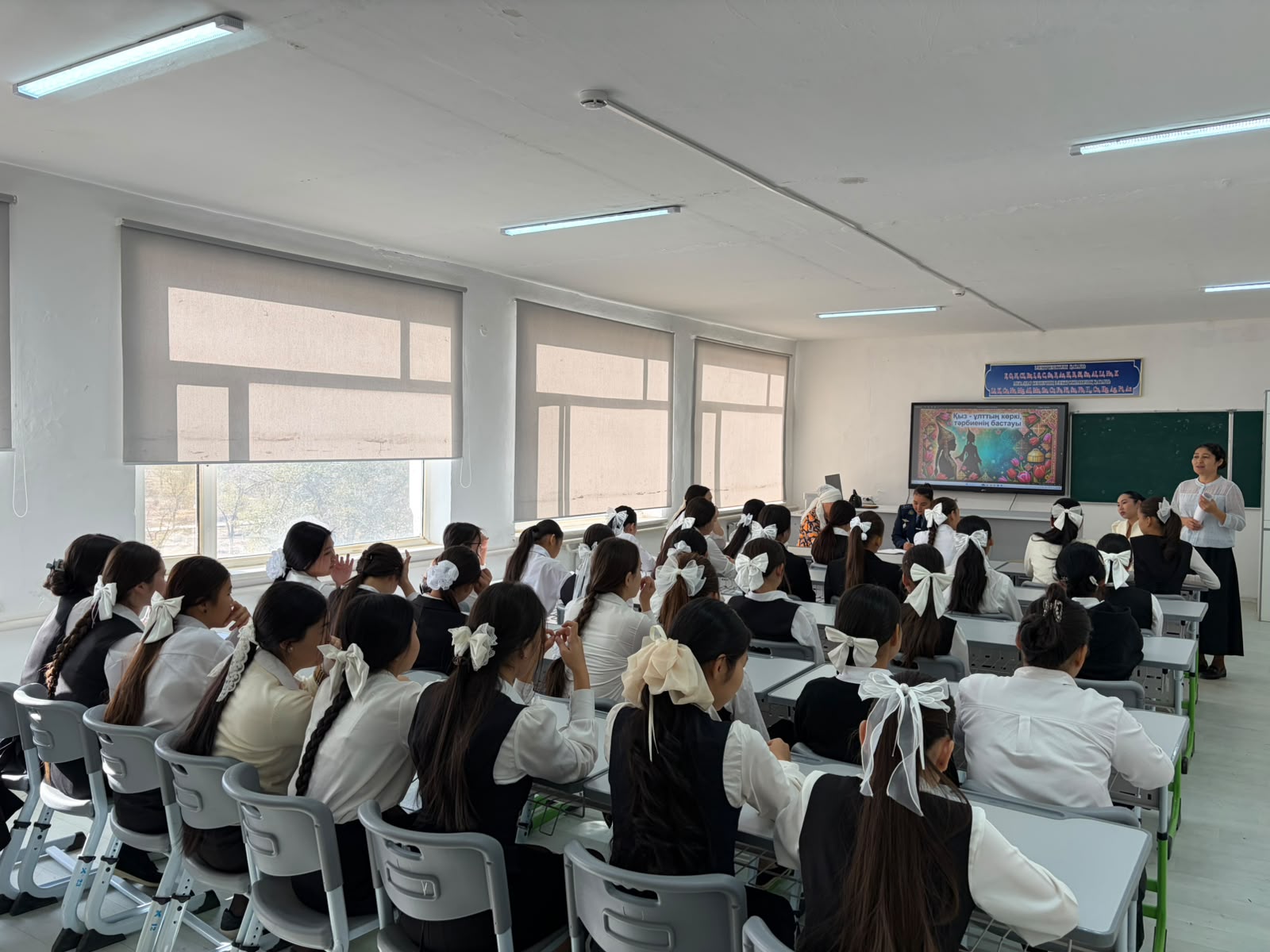 Сыныпта мұғалімнің сабақ өткізіп жатқан сәті және оқушылардың тыңдап отырғаны.
