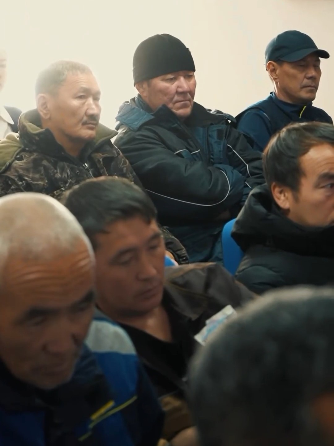 Жиынға жиналған ер адамдардың тобы.