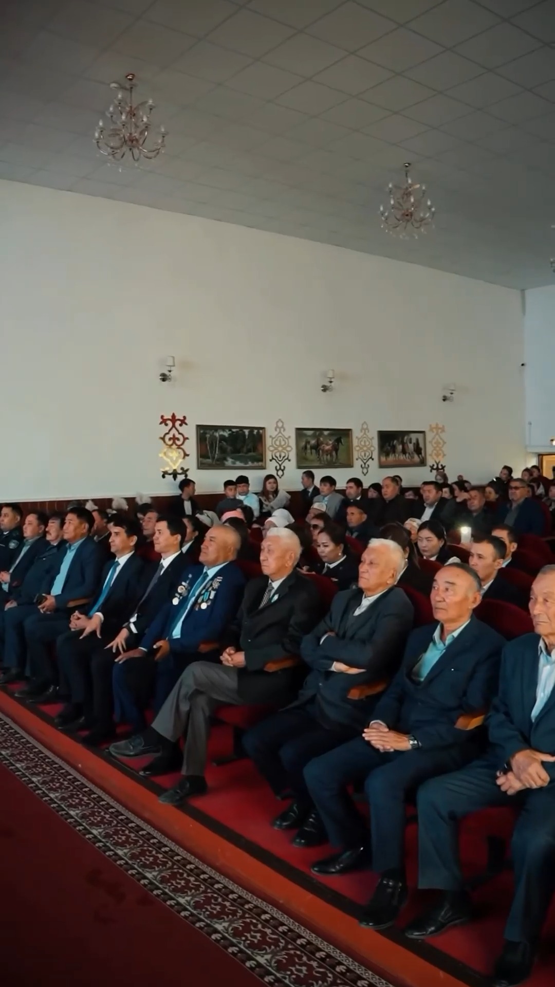 Залға жиналған костюм киген ер адамдар мен қарттардың тобы.