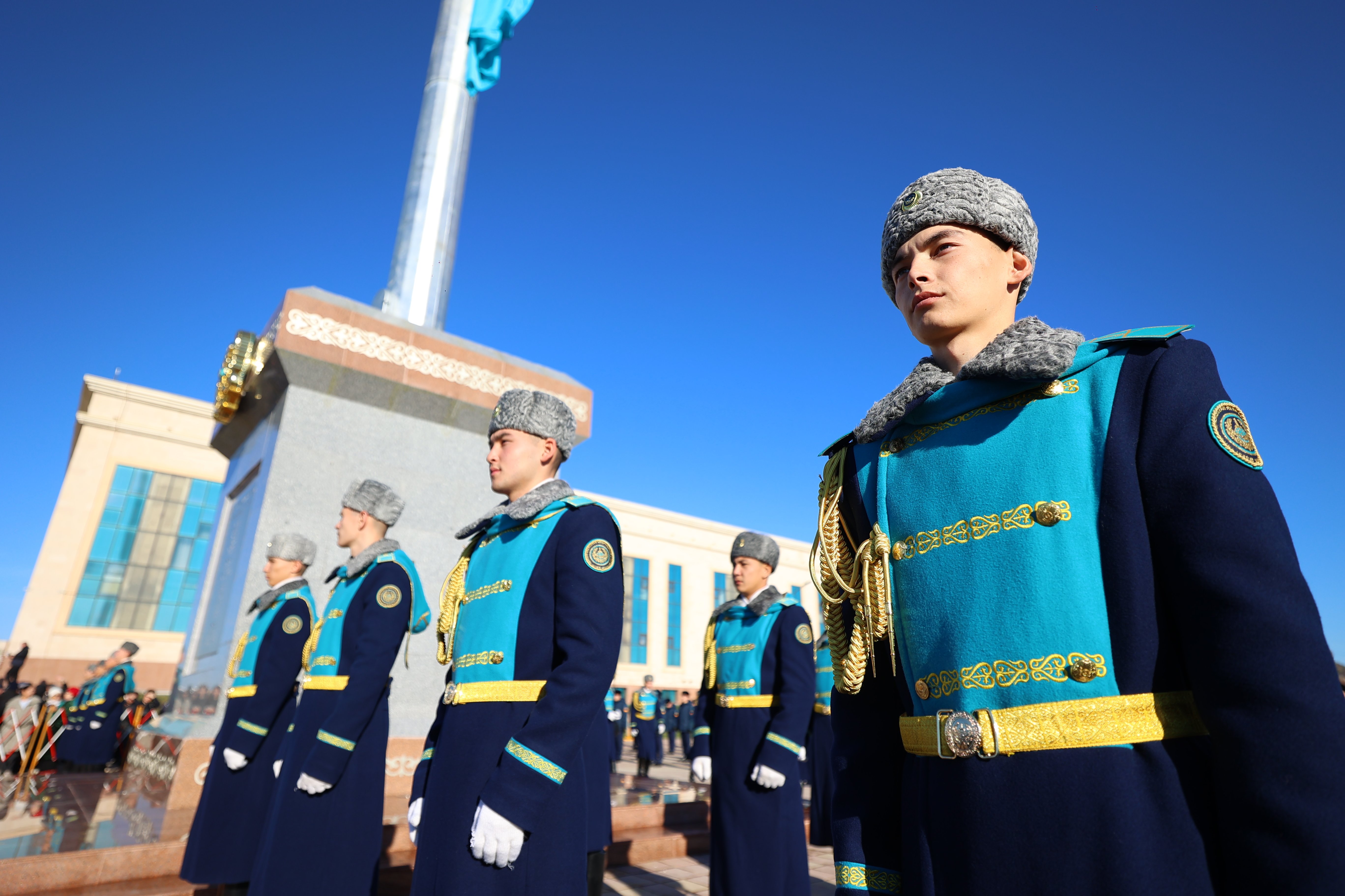 Қазақстанның салтанатты киіміндегі құрмет күзеті сатырында тұр.