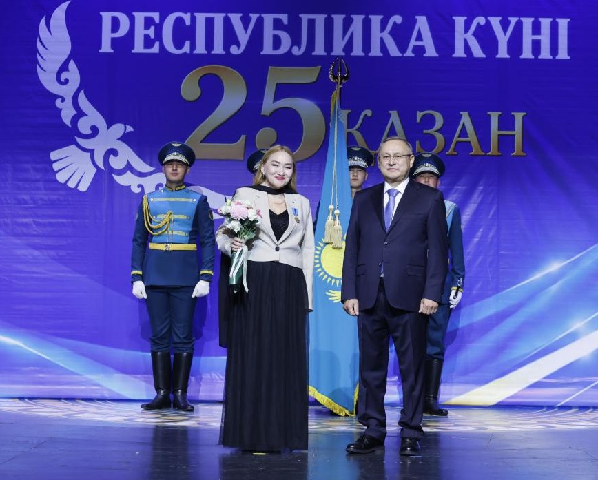 Қазан қаласында Республика күніне арналған іс-шарадағы адамдар. Фонда «Республика күні 25 Қазан» жазуы бар.