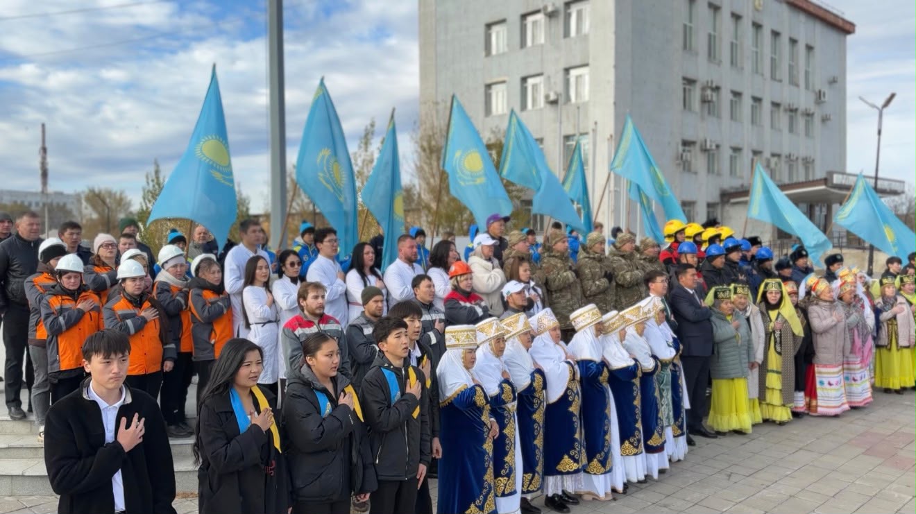 Қазақстан туларын ұстаған әртүрлі мамандықтағы адамдар мен ұлттық киімдегі жастардың жиыны.