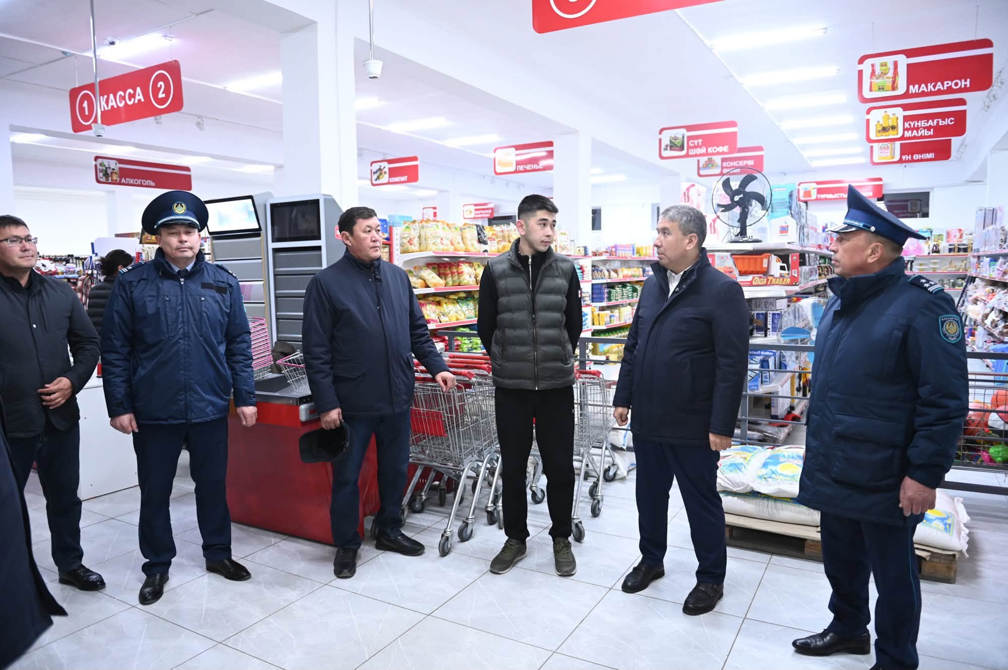 Азық-түлік дүкеніндегі полиция қызметкерлері мен азаматтардың әңгімелесуі.