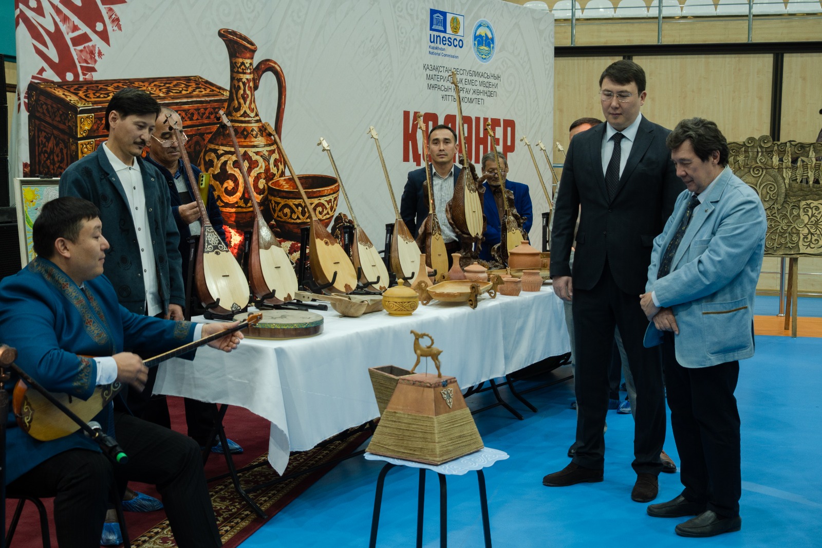 Қазақ халқының ұлттық аспаптары мен қолөнер бұйымдары қойылған көрмедегі адамдар.